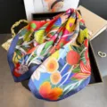 Foulard carré en soie artificielle imprimé de fleurs vibrantes et élégante bordure bleue en détail. - FG330-4