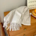 Detail view of the soft wool loop yarn winter warm scarf with cozy fringe design in beige. - Off White