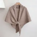 Gebreide sjaal detail toont zachte textuur en knoopontwerp voor gezellige winterwarmte. - Khaki