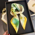 Silk printed scarf detail view showing green and yellow floral pattern and smooth fabric. - FG137-3 Green