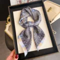 Close-up shot of a vintage paisley print silk square scarf, elegant neck accessory detail. - Light Blue