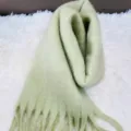 Detailed shot of the soft mint green fluffy mohair scarf texture, thick winter tassel knit. - Light Green