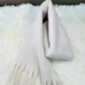 Detailed view of a thick winter scarf featuring soft texture and elegant fringe design. - White