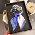 Detailed shot of a chic blue and white contrast printed square scarf, elegant accessory. - Blue