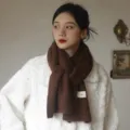 Cozy brown knitted scarf detail shot featuring a soft textured fabric and a cute mini label. - 220cm / Chestnut