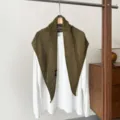 Close-up detail of the olive green crochet knit triangular shawl hanging on white tee. - Olive Green