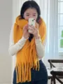 Close-up details of the thick yellow knitted winter tassel scarf, very cozy and warm. - Turmeric