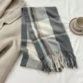 Cozy grey plaid winter scarf with chic fringe detail, flat lay scene with coat. - Size 5 / 180cm
