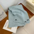 Light blue knit winter scarf detail, cozy wool material with cute black bow decorations for warmth. - Sky Blue