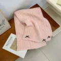 Pink knitted winter scarf with cute black bow decoration, cozy cable knit fabric accessory. - Pink