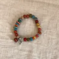 Pulsera de cuentas de cerámica y madera estilo étnico vintage con dije de corazón, vista detallada. - Estilo 3