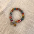 Primer plano detallado de la pulsera de cuentas étnicas con dijes de cerámica y madera. - Estilo 2