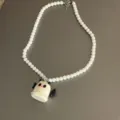 Close-up detail of the white beaded necklace with cute little ghost pendant for festival style. - Style 2 (White Winged Ghost)