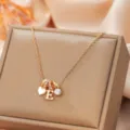 Elegant gold-toned pendant necklace featuring letter E charm, heart and sparkling crystal. - Letter E