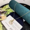 Detail shot of a gold zodiac pendant necklace resting on a stylish green velvet display prop. - Scorpio