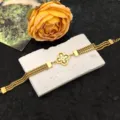 Close-up detail of the gold multi-strand chain bracelet featuring a sparkling crystal clover motif. - Clover Flower Bracelet / Gold