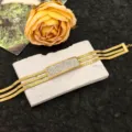 Primo piano dettagliato di un bracciale a catena a serpente dorata con strass brillanti. - Bracciale Quadrato Pavimentato in Strass / Oro