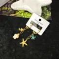 Orecchini pendenti in acciaio inossidabile dorato tema mare con tartaruga e stella marina. - Orecchini a Bottone Tartaruga Multielemento / Oro