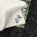 Vista dettagliata di un anello aperto in argento con design a coda di balena e zirconi blu brillanti. - modello 3