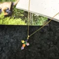 Close-up detail of the colorful zirconia cross pendant necklace, elegant gold chain design. - Style 7