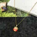 Collana in acciaio al titanio dorato con ciondolo gatto portafortuna in zircone e smalto rosso. - Collana Gatto della Fortuna / Oro