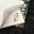 Gros plan détaillé de la bague ouverte dorée ornée de délicats cristaux scintillants. - Style 7