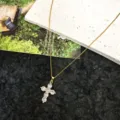 Detailed shot of a delicate gold-toned chain necklace featuring a sparkling crystal cross pendant. - Style 5