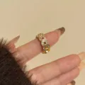 Gedetailleerde close-up van een gouden ring met antiek muntmotief en zirkonia stenen. - A Goud-3121