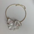 Close-up detail of the gold-toned choker necklace featuring a pearly glazed enamel butterfly pendant. - Choker (3872)