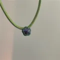 Detail shot of a niche designer green PU leather choker necklace with a purple crystal flower. - Flower Style