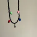 Gedetailleerd overzicht van een zwarte kralenketting met kleurrijke schedelbedeltjes. - Kleurrijke Schedels Stijl (07)