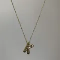 Detailopname van de vergulde puffy letter K hanger halsketting met fijne kralenketting. - Goud K