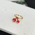 Vista dettagliata del dolce anello aperto con ciliegia rossa, finitura oro e cristallo brillante. - Stile Ciliegia Smaltata Rosso Verde Strass con Fiore (4)