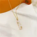 Primo piano della raffinata collana con ciondolo in calcedonio bamboo e dettagli di pietre. - Stile Bambù Bianco Strass Bianco (Catena a O) / Bianco
