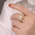Primo piano dettaglio anello perla di lusso con cristalli luminosi su fascia dorata. - Anello avvolgente / Oro