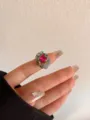 Detail van dikke grijze emaille ring met sprankelende roze kristal en sierlijke gouden rand. - Grijs Emaille Grote Roze Kristal Stijl