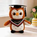 Cute graduation owl plush toy wearing a black mortarboard cap and graduation scarf, ideal gift. - Red Triangle Scarf Style