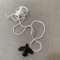 Black ceramic bird pendant necklace with white rope cord, stylish sweater chain accessory. - Black Dove White Cord