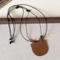 Brown leather glasses holder necklace with black cord, portable eyewear storage strap for travel. - Glossy Leather Brown Crescent Double Layer Necklace