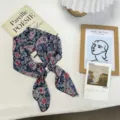 Detailed view of vintage navy blue paisley floral printed silk scarf with elegant pearl ring buckle. - One Size / Navy Blue