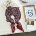 Close-up of the vintage red patterned silk square scarf featuring an elegant pearl buckle. - Style 03 / One Size / Burgundy