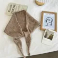 Detail view of a stylish brown knitted triangular scarf, cozy neck warmer for autumn and winter. - 130x24cm / Brown