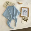 Close-up of light blue knit triangular scarf detail, soft texture with tie strap and cute label. - 130x24cm / Blue