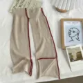 Minimalist beige knit leg warmers detail view showing exquisite red split edge design. - One Size / Milk Coffee