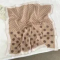 Detail view of the brown polka dot silk scarf, showing soft fabric texture and elegant pattern. - 68*68cm / Coffee