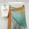 Primo piano dettaglio di foulard da cintura a strati alla moda abbinato al denim. - Blu