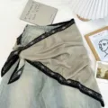 Detailed shot of retro color block triangle scarf styled on denim, chic fashion accessory. - Oatmeal
