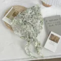 Detailed shot of the floral print triangle scarf, lightweight fabric with green lily pattern. - 110*30cm / Lily