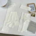 Close-up detail of the lightweight white solid three-piece set with aesthetic props. - One Size / White