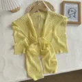 Détail de châle en tricot ajouré jaune, texture en soie de glace et design de nouage avant. - Hauts / Taille unique / Jaune